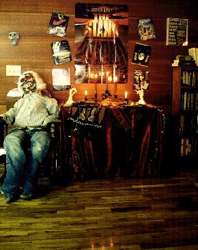 The Dead Dude sits in the antique rocking chair near the door of the Stronghold's party room.