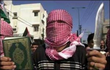 A Muslim holding the Koran
in his right hand and a knife in his left hand