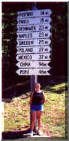 Becki at the sign showing every country in Maine