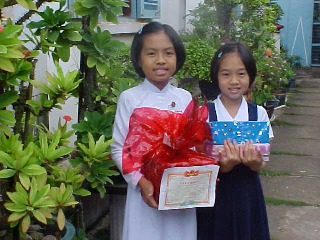 Click to go to full-size photo of Thao1 and Thao2 with school awards