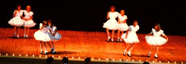 Cloggers with traditional dress and stage positioning.