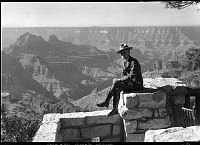 SUPT. TILLOTSON SITTING ON THE WALL OF PATIO, GRAND CANYON LODGE - NORTH  RIM - CANYON IN BACKGROUND. 25 JUL 1930. NPS PHOTO.