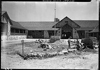 RECONSTRUCTION OF GRAND CANYON LODGE ON   NORTH RIM. FRONT ENTRANCE CURB & GROUNDS WORK.  BUILDING ALMOST COMPLETE. 15 JULY 1937. NPS PHOTO<br>