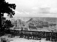 VIEW FROM NORTH RIM GRAND CANYON LODGE EAST PORCH WITH PATIO CHAIRS BEHIND RAILING. JULY 1930. NPS, GRANT