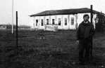 Former camp guard Veljko Grmusa, leaning on the barbed wire fence pole