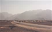 The road from Nakhl to Barka with the mountains of Al Hajar al Gharbi in the distance