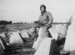 Soldier sitting on dragon's tooth in tank trap