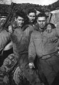 three soldiers posing beside halftrack