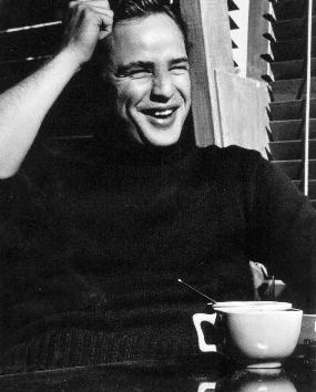 Black and white photo of Marlon Brando with a big cup of coffee and wearing a black turtle-neck sweater, from (I presume) the late 1950's