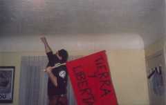 Personaje: Pedro Barrios, sosteniendo la bandera Roja de Tierra y Libertad, la bandera anarquista mexicana.
