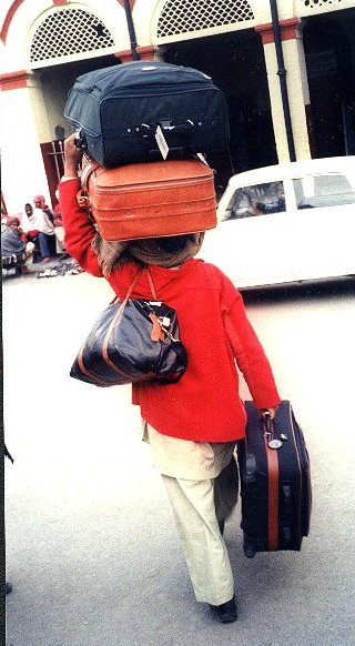 Porter Loaded with Suit Cases