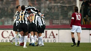 Juventus players celebrate as Roma's Francesco Totti looks on