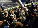 and holding the trophy aloft