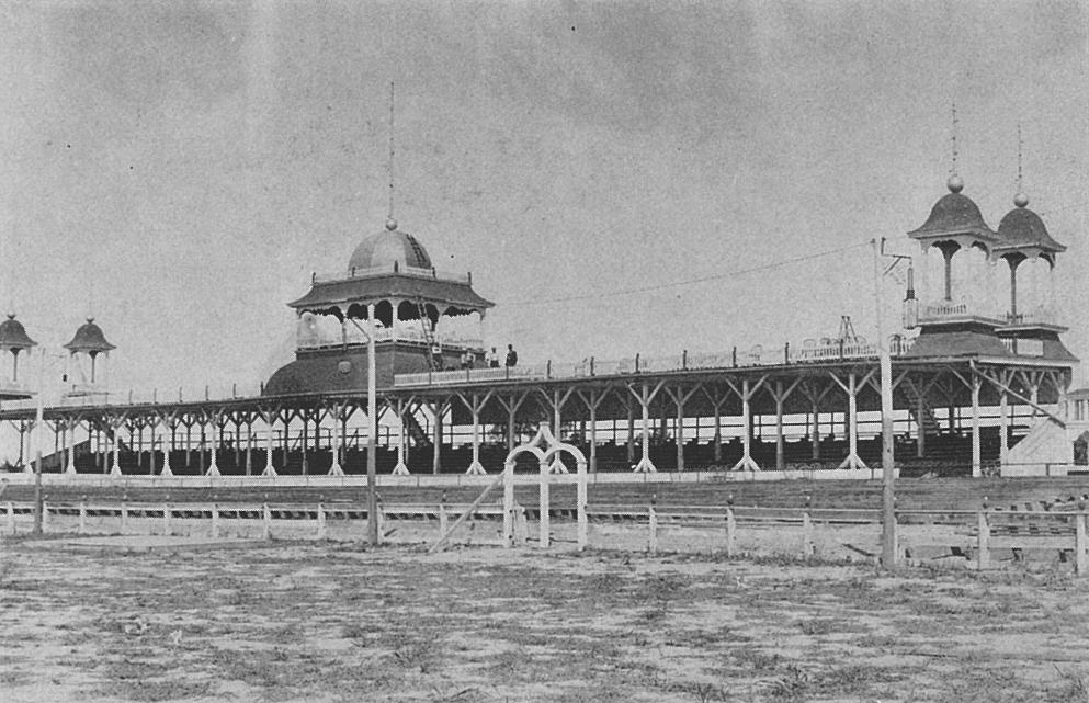The Grandstand with cupola seating areas atop.  Note the stairways leading to upper seats and the workmen with ladder.