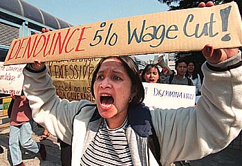 A Filipina worker protests the wage cut (www.ahram.org.eg)