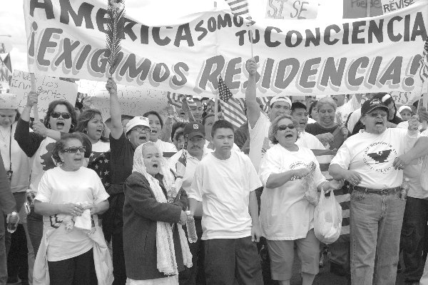 manifestantes en Fresno 2006, con bandera 'America, somos tu conciencia, exigimos residencia'