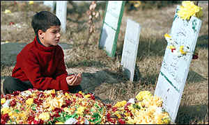 A youngster in Kashmir prays at his father's grave, another victim of the genocide by the indian army