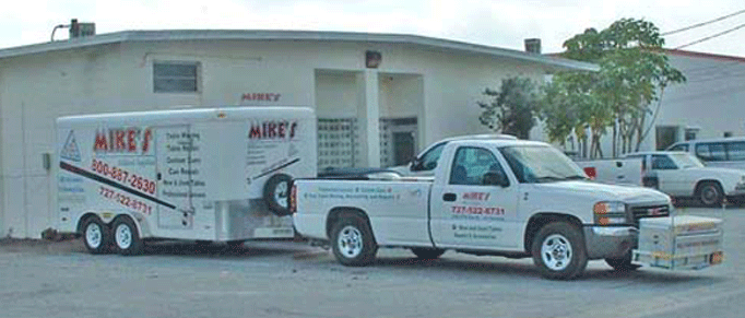 GMC 2004 Tow vehicle and a 14' cargo trailer setup specially to transport pool tables and billiard tables safely in the 55 Counties in Florida that Mike's Billiard supplies and Crating provides service to.