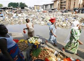 The waste is in the sea and in city waterways near the market area. These women are protecting themselves from the noxious fumes given off by the sludge.