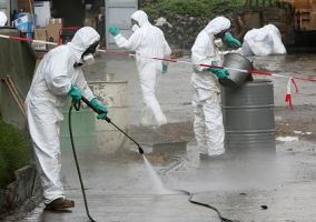 Experts cleaning up toxic waste in the village of Akuedo in Ivory Coast on Monday. The waste has led to several deaths and dozens of illnesses in the country.
