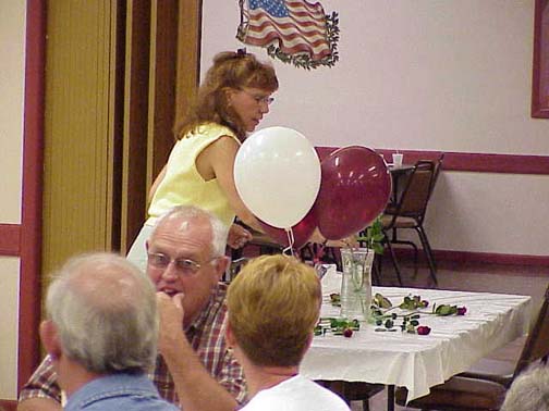 Ilene (Yorio) Hamm presenting a rose in memory of a deceased classmate