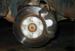 After removing the wheel, undo the caliper retaining bolt (on the lower rear side of the caliper - 14mm) and then you can swing the caliper up and remove it from the bracket.