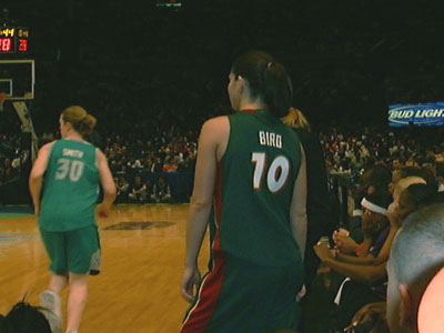 Sue Bird is watching the game while being interviewed by Doris Burke