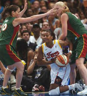 Tamika Catchings looks to pass as she is double teamed by Sue Bird and Lauren Jackson.