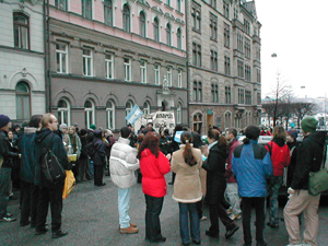 Flertal icke-funktionshindrade manifestanter, med en banderoll i bakgrunden.