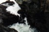 tide surges over seaweed between the rocks