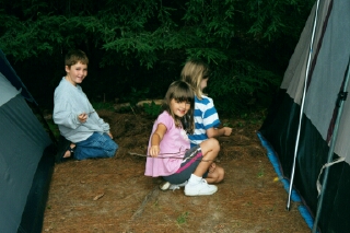 Atticus, Hannah, and Julia between the tents, mixing potions