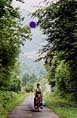 Sheila pushing her bike up a steep road in the foothills