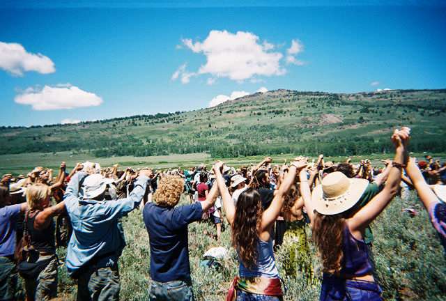 thousands of people hold hands and chant OM to bring peace to the world