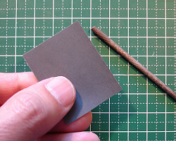 Sanding with a rolled piece of sandpaper.