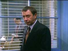 people can be seen in the next office through the window between them