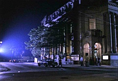 the entrance to the parking lot, with the 96th Precinct building on the right