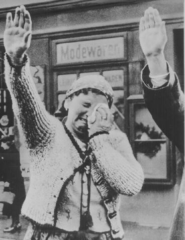 A Czech woman weeps while saluting Nazi occupiers