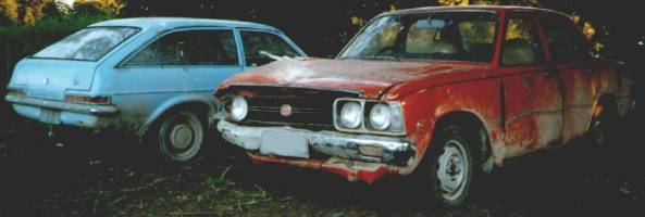 two beatup muddy cars