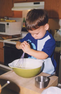 Stirring the pancakes on Sunday morning. [22,880 bytes]