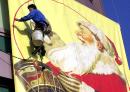A Chinese worker wipes a big banner featuring Santa Claus Wednesday, Dec. 6, 2000 at a foreign-invested department store in Shanghai. (AP Photo/EugeneHoshiko)
