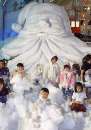 Singaporean children frolic in imitation snow under a giant Santa Claus outside a shopping mall in the equatorial island republic December 8, 2000. The foam snow is part of the shopping cener's Christmas theme, and to lure customers. Christmas is popular in Singapore despite a predominance of Bhuddhists and Taoists in the mostly ethnic-Chinese city state, which has a population keen on shopping. REUTERS/Claro Cortes IV