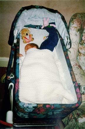 Nathan in his carry cot with his Christmas Stocking