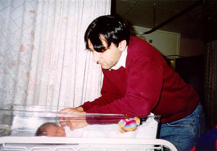 Dad holding his son's hands (and in need of a hair cut)