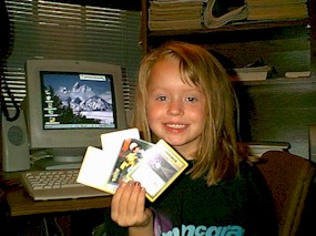 Linsey holding some Pokemon cards. Grandpa's computer in the background.