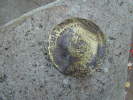 The geological survey marker at the actual marker. The marker is atop a large boulder