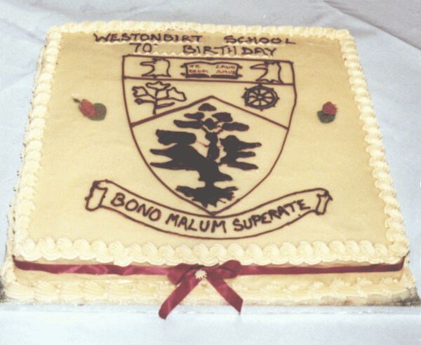 picture of cake with school arms and motto - a flat square cream-coloured iced cake, with maroon ribbon round it.