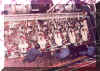 Customs officers rummaging the engine room of a ship wearing boiler suit