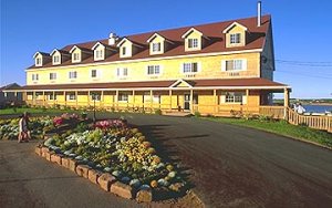 the stanley lodge hotel has a small rock garden and a road in front of it.