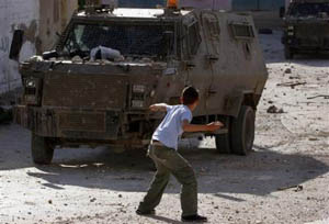 enfant palestinien jetant des pierres contre un tank