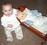 20050314_02b-Emily-8mo_checkingDollyinCradle.jpg